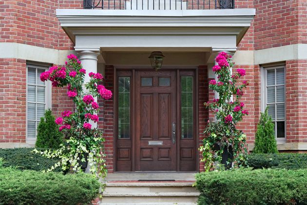 Get creative with your portico decorations! Consider hanging wreaths on the front door or having greenery nearby, as with this portico.