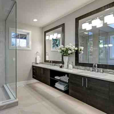 Modern bathroom remodel in nj featuring black vanities and white marble flooring